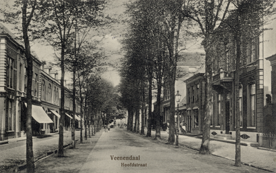 14676 Gezicht in de Hoofdstraat met rijen loofbomen en bebouwing te Veenendaal.